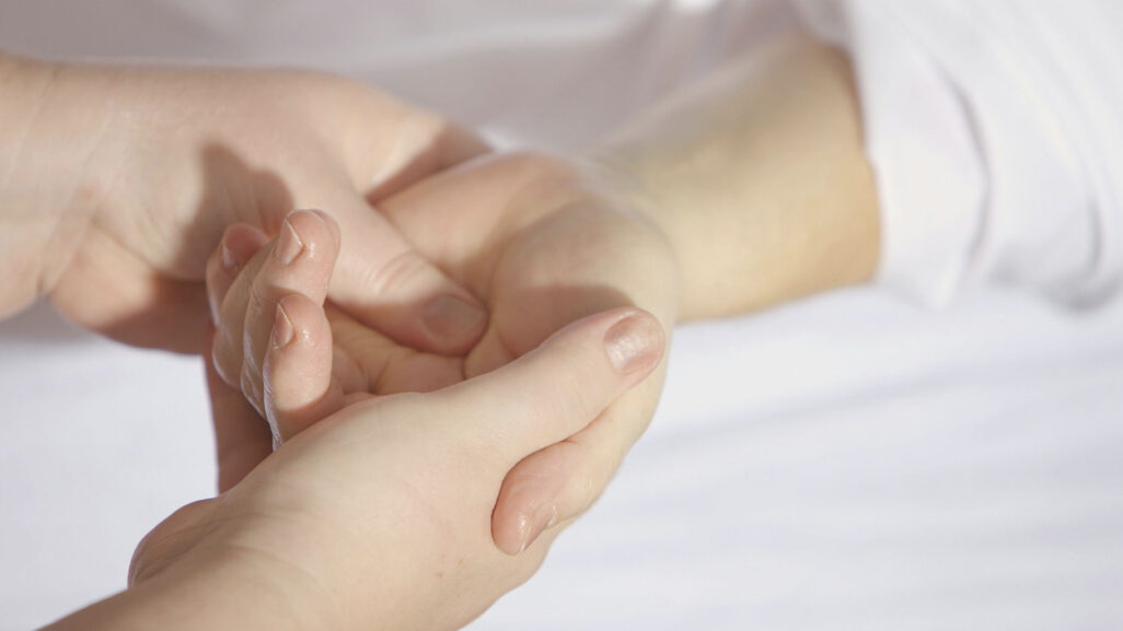 a close up shot of a therapist holding a patient's hand
